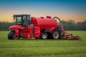 Farmer using improved methods of agriculture with modern farming equipment in a green agricultural field